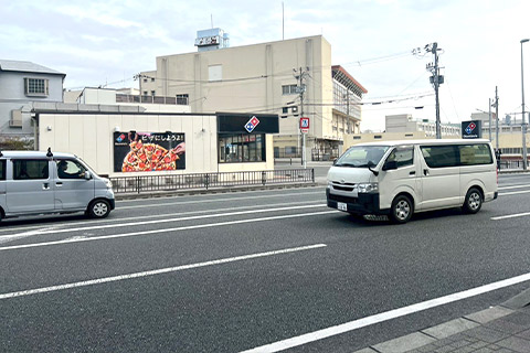 しばらく直進すると、左手にドミノ・ピザが見えてきます。 その向かい側(国道25号線を挟んだ反対側)にあるビルが目印です。